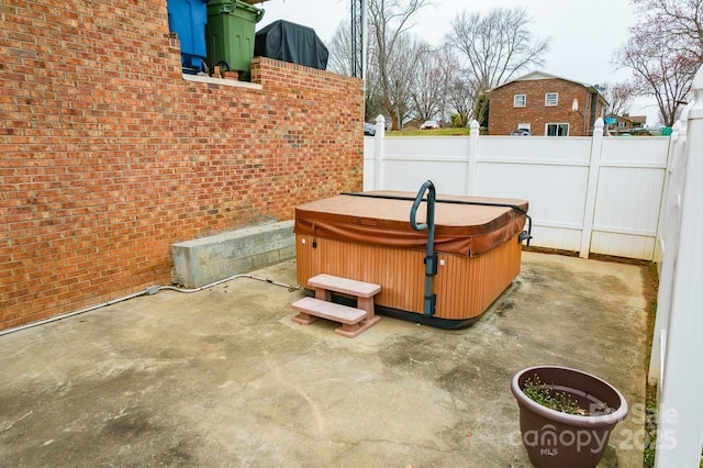 view of patio / terrace featuring fence and a hot tub