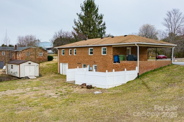 rear view of property featuring brick siding, a shed, a yard, and an outdoor structure