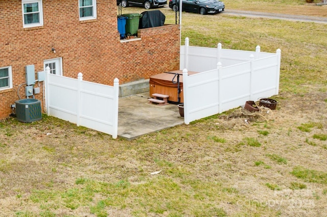 exterior space featuring a patio area, central AC unit, fence, and a lawn