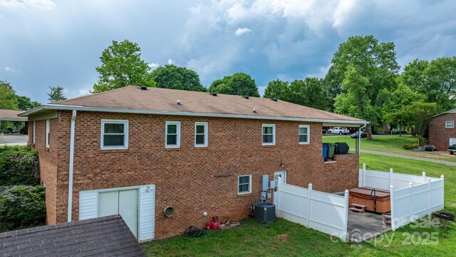 2609 Raintree St, Connelly Springs, NC 28612 - rear view of house featuring brick siding, a hot tub, and roof with shingles