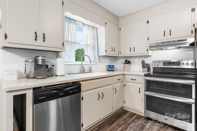 2609 Raintree St, Connelly Springs, NC 28612 - kitchen featuring appliances with stainless steel finishes, under cabinet range hood, a sink, backsplash, and dark wood finished floors