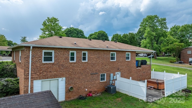 2609 Raintree St, Connelly Springs, NC 28612 - back of house featuring brick siding, a hot tub, roof with shingles, and central AC