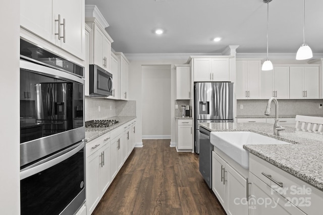 kitchen featuring white cabinets, dark wood finished floors, hanging light fixtures, stainless steel appliances, and crown molding