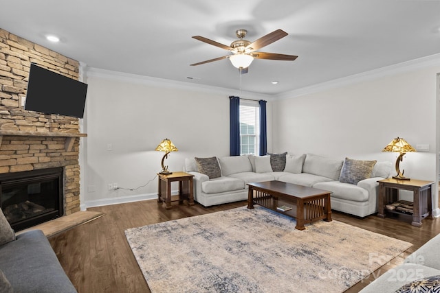 living area featuring ornamental molding, a fireplace, wood finished floors, and baseboards