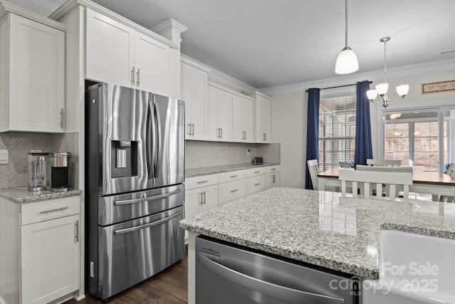 kitchen with ornamental molding, appliances with stainless steel finishes, a chandelier, and white cabinets