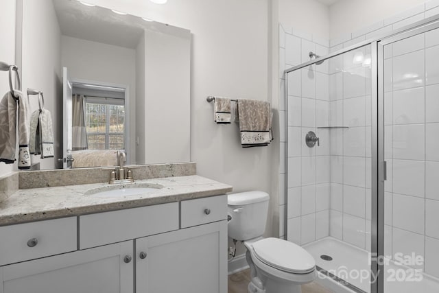 bathroom featuring toilet, ensuite bath, a shower stall, and vanity