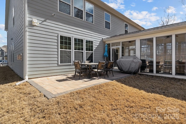 rear view of house featuring a sunroom and a patio