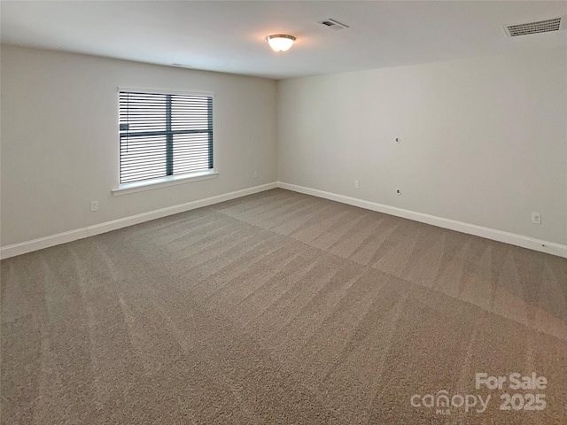 unfurnished room with carpet floors, baseboards, and visible vents