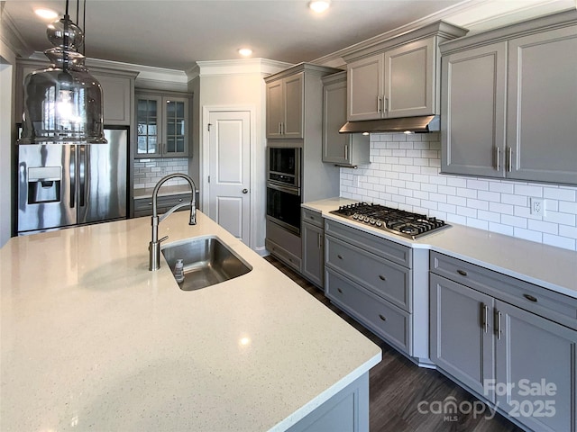 kitchen featuring appliances with stainless steel finishes, a sink, under cabinet range hood, and gray cabinetry