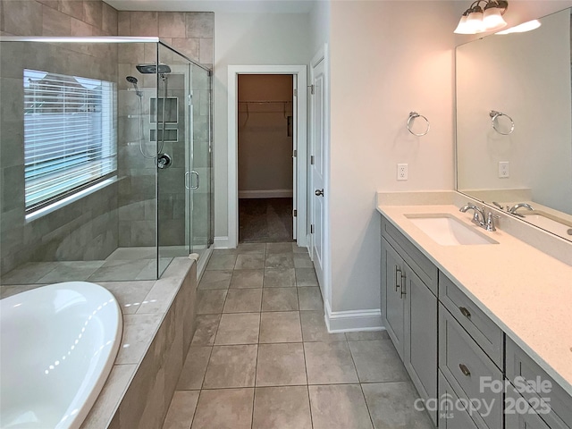 full bathroom with vanity, a bath, tile patterned floors, a stall shower, and a walk in closet