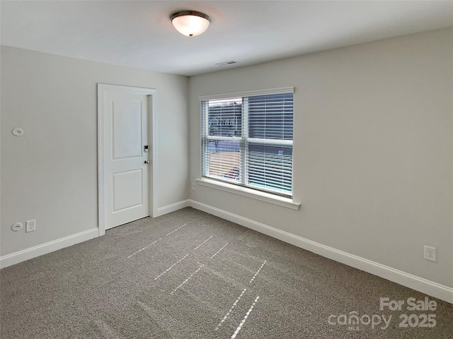 carpeted spare room with visible vents and baseboards