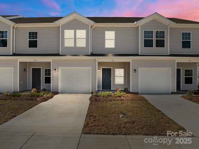 multi unit property with a garage and concrete driveway