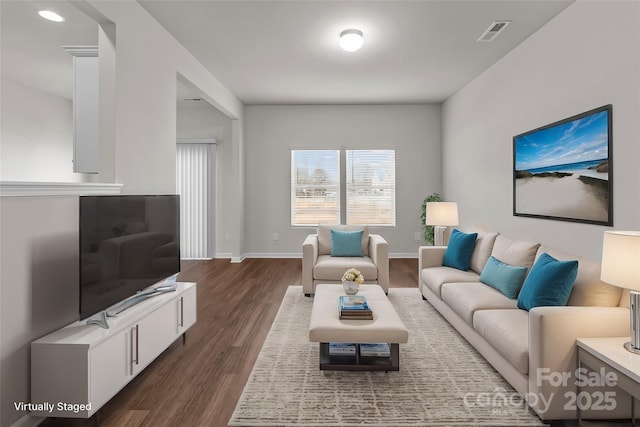 living room with dark wood-type flooring, visible vents, and baseboards