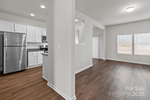 kitchen with dark wood finished floors, stainless steel appliances, recessed lighting, white cabinets, and baseboards