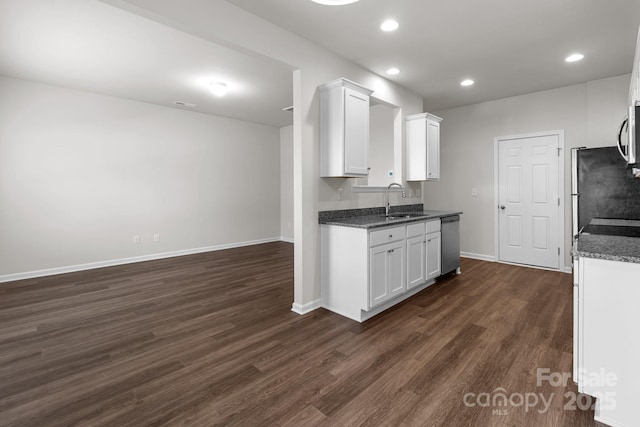 kitchen with stainless steel appliances, dark wood-style flooring, white cabinets, and a sink