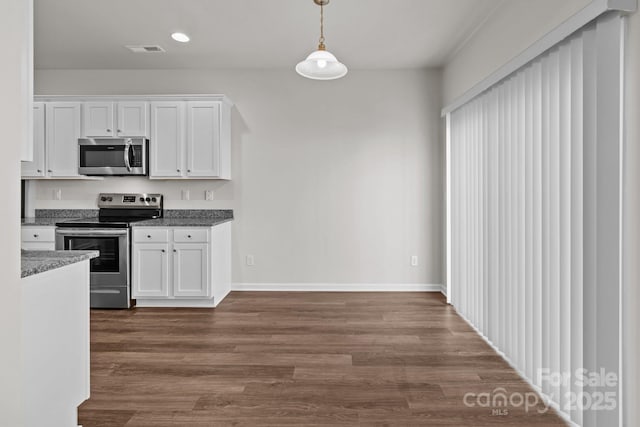 kitchen with pendant lighting, dark wood finished floors, stainless steel appliances, visible vents, and white cabinets