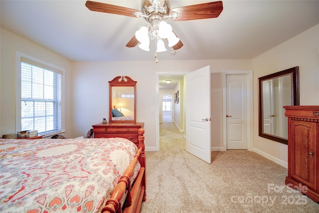 bedroom featuring baseboards, a ceiling fan, and light colored carpet