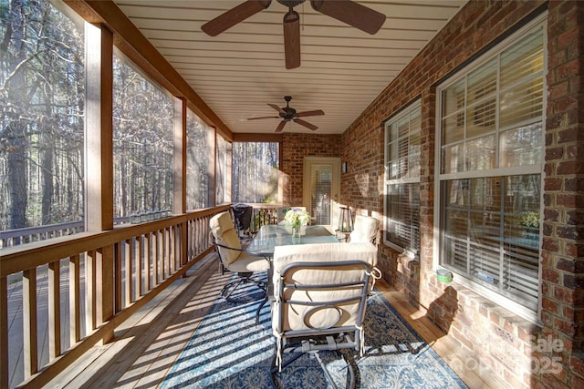 sunroom with outdoor dining area and ceiling fan