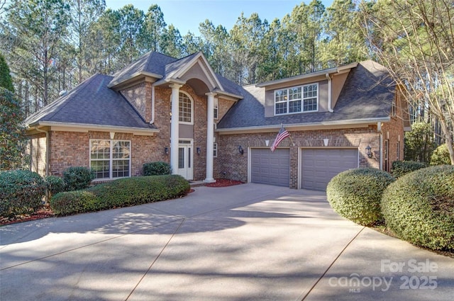 view of front of house featuring concrete driveway, brick siding, and a shingled roof