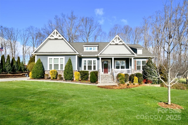 craftsman house featuring stone siding, a porch, and a front lawn