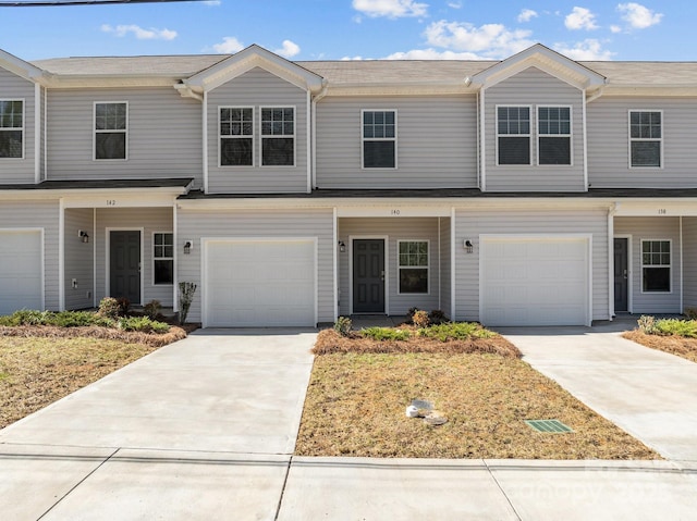 view of property featuring concrete driveway and an attached garage