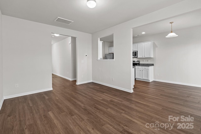 unfurnished living room featuring dark wood-style flooring, recessed lighting, visible vents, and baseboards