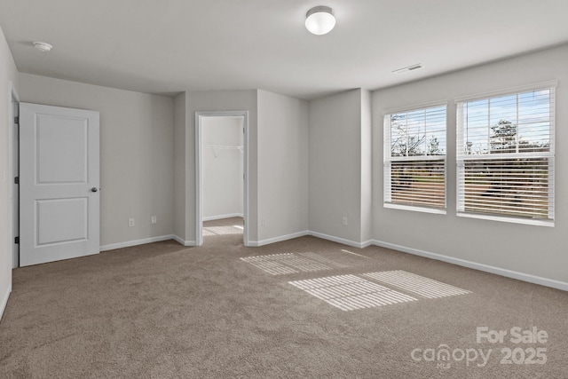 carpeted empty room featuring visible vents and baseboards