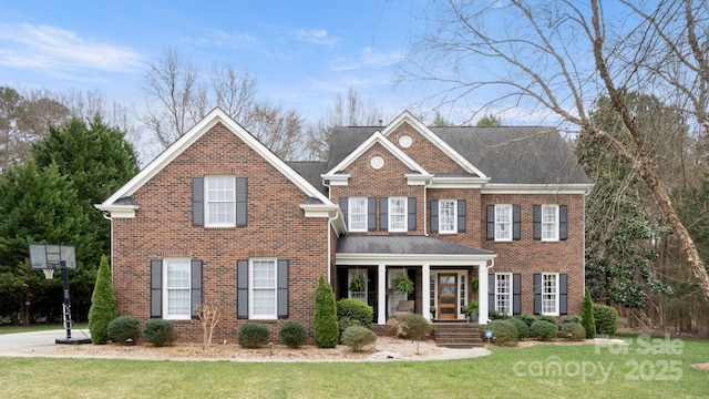 view of front of home with brick siding and a front lawn