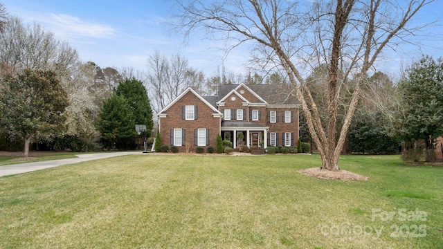 view of front facade featuring brick siding and a front yard