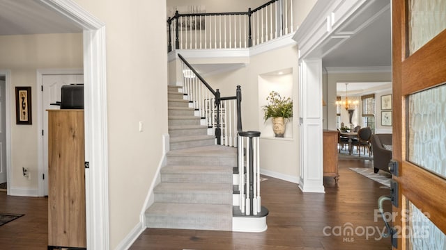 foyer featuring baseboards, a chandelier, stairway, a high ceiling, and wood-type flooring