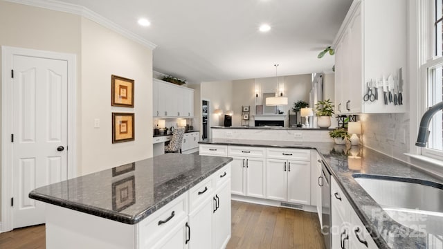 kitchen featuring a sink, decorative backsplash, dark wood finished floors, and white cabinetry