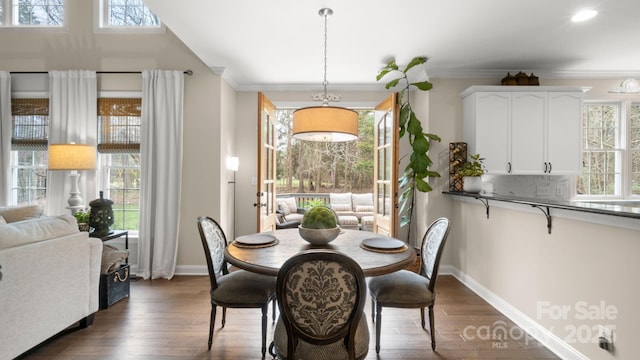 dining area with plenty of natural light, dark wood-style floors, and crown molding