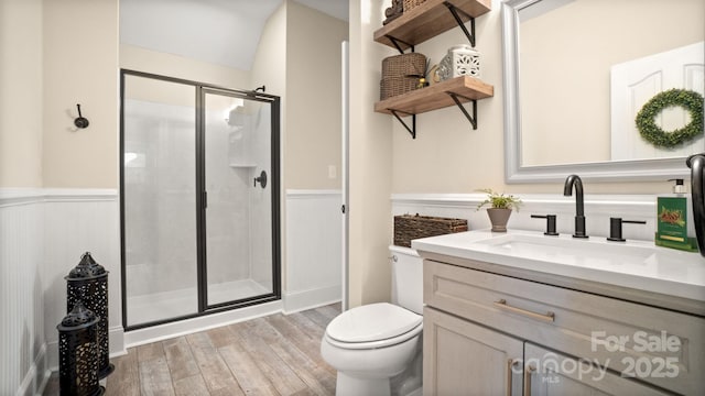 full bathroom featuring a stall shower, wainscoting, wood finished floors, and vanity