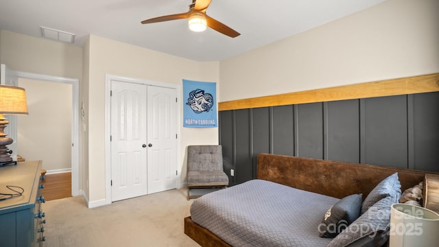 carpeted bedroom with baseboards, visible vents, a closet, and ceiling fan