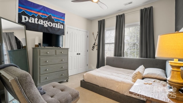 bedroom with visible vents, carpet, a closet, and a ceiling fan