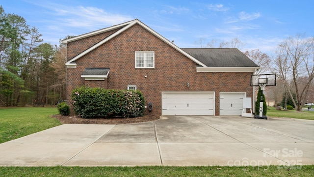 view of side of property with a garage, concrete driveway, a yard, and brick siding