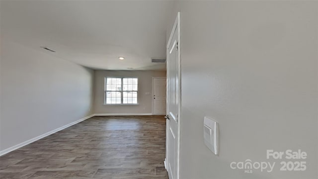 spare room with visible vents, baseboards, and dark wood-style flooring