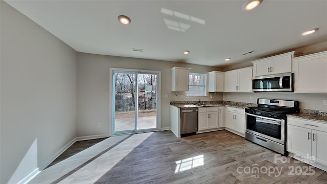 kitchen featuring visible vents, appliances with stainless steel finishes, baseboards, and light wood-style floors