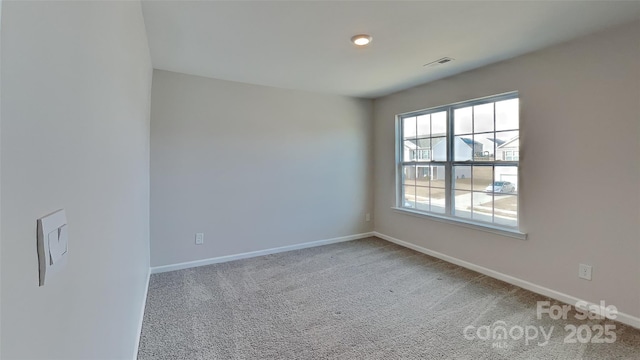 carpeted empty room featuring baseboards and visible vents