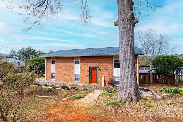 exterior space with brick siding and fence