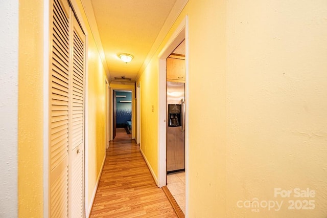 hall with light wood finished floors and baseboards