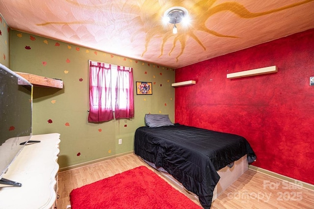 bedroom featuring baseboards and wood finished floors