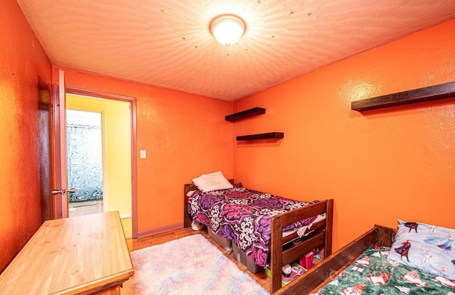 bedroom with baseboards and wood finished floors