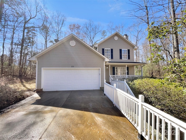 traditional-style house with a garage, covered porch, driveway, and a chimney