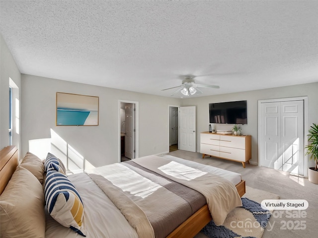 bedroom with a closet, light colored carpet, ceiling fan, and a textured ceiling