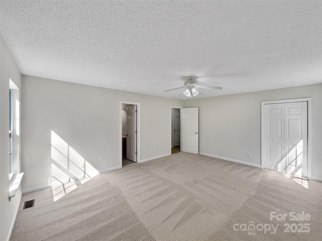 interior space with a ceiling fan, baseboards, visible vents, and a textured ceiling