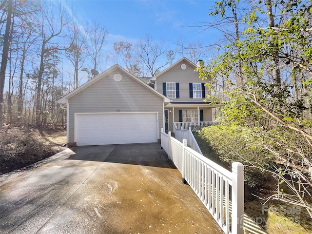 traditional-style home with an attached garage, covered porch, and concrete driveway