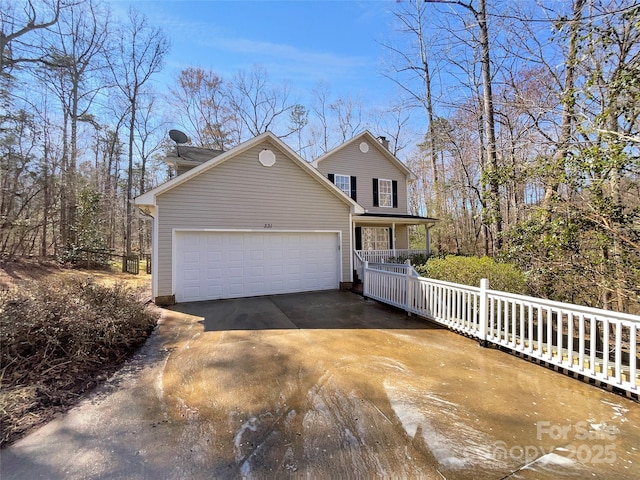 traditional home with a porch, driveway, and an attached garage