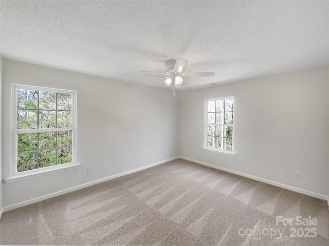 carpeted spare room featuring ceiling fan, a textured ceiling, and baseboards