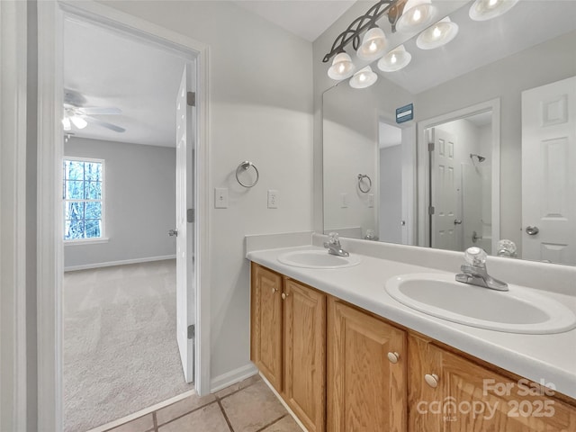 bathroom featuring double vanity, tile patterned flooring, baseboards, and a sink